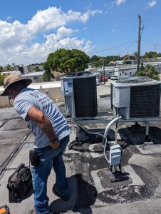 AC technician inspecting rooftop air conditioning units